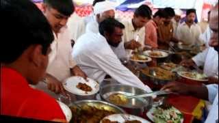 Men grabbing food at a wedding reception in Pakistan [upl. by Einwahs]