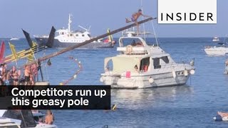 This traditional competition has competitors run up a greasy pole [upl. by Otrevogir]