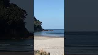 A surfer kayaker and a boat all out in the calm sea at Waihi Beach North Island New Zealand [upl. by Vivien]