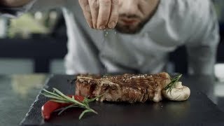 Chef Salt Frying Meat at Griddle Closeup Man Hands Salt Steak in Slow Motion  Stock Footage [upl. by Kimberley]