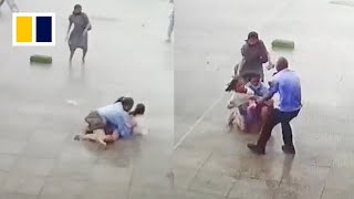 Security guard helps pedestrians knocked off feet in strong winds [upl. by Groscr]