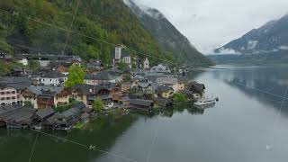 Aerial views highlight Hallstatt Austria a UNESCO World Heritage site featuring a tour boat [upl. by Irrac]