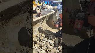 A worker uses a perforator to clean a loader bucket [upl. by Anileh]