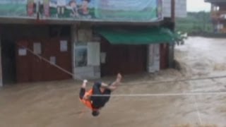 Dramatic footage Man winched across fastflowing river in China after becoming trapped in his home [upl. by Damek211]