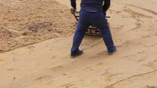 worker with vibration plate compactor ramming sand on construction site before paving [upl. by Dnomasor829]